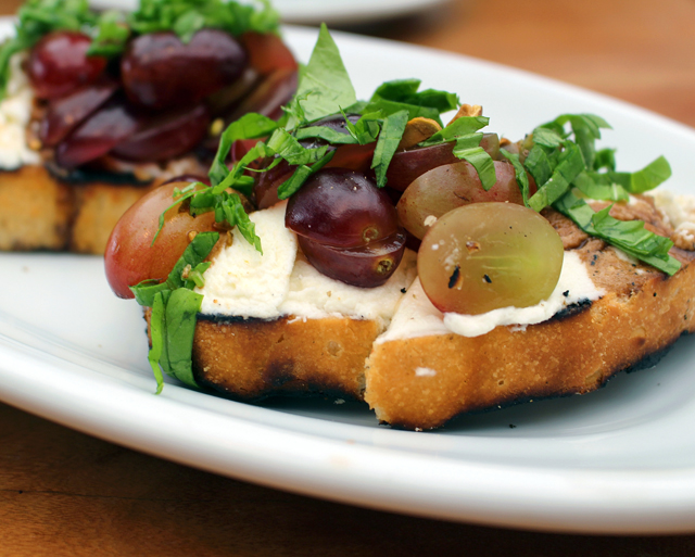 Bruschettas de queijo de cabra com uvas, pistache e mel orgânico 