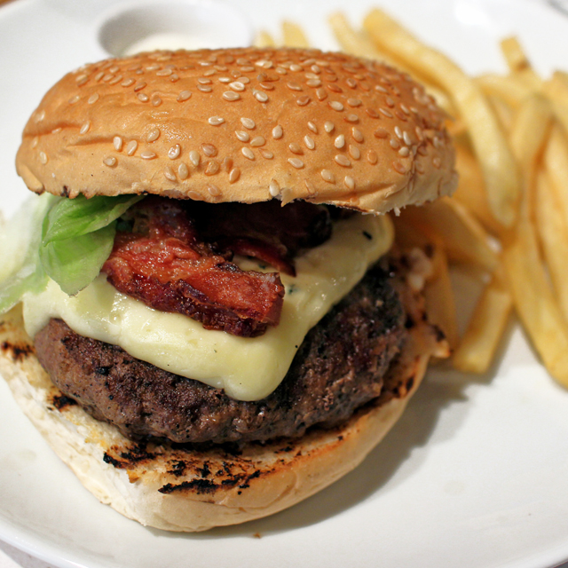Burger da casa (hambúrguer com cheddar ou gorgonzola, panceta, alface americana, acompanhado por fritas e maionese de mel e limão siciliano, R$ 24) 