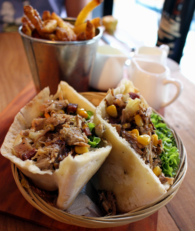 Excelente opção do menu de sanduíches no pão pitta: Suprema, montado com carne de porco desfiada, alface, queijo, bacon, milho e pedaços de abacaxi 