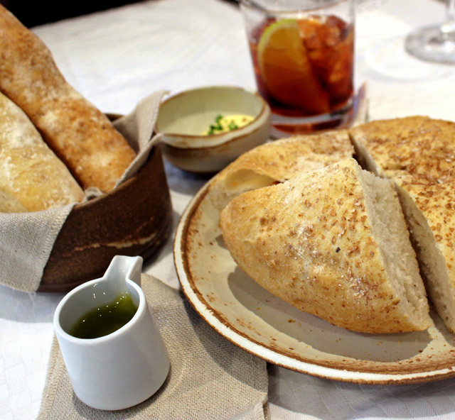 couvert: pães feitos na casa, como o de estilo italiano com amêndoas e a ciabatta, acompanhados por azeite de oliva e manteiga com ervas.