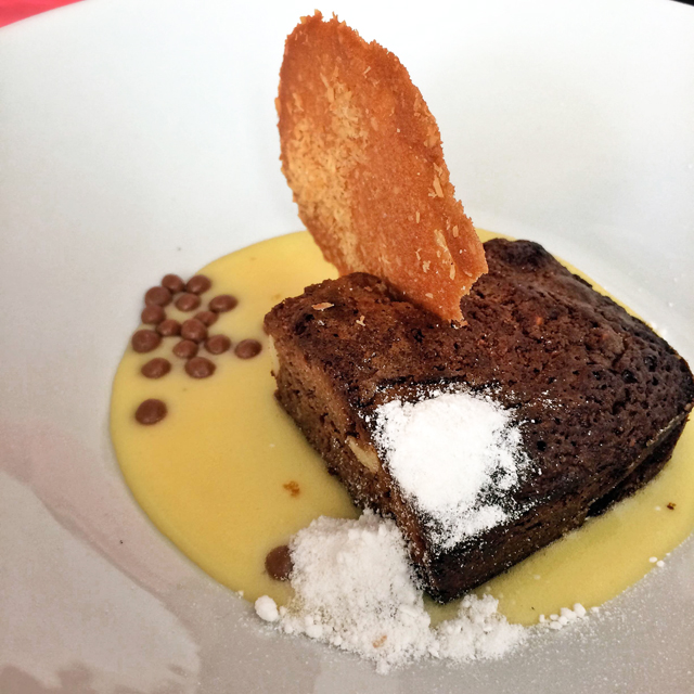 Impecável: Brownie de chocolate repleto de castanhas, creme de maracujá, pó e tuile de coco 