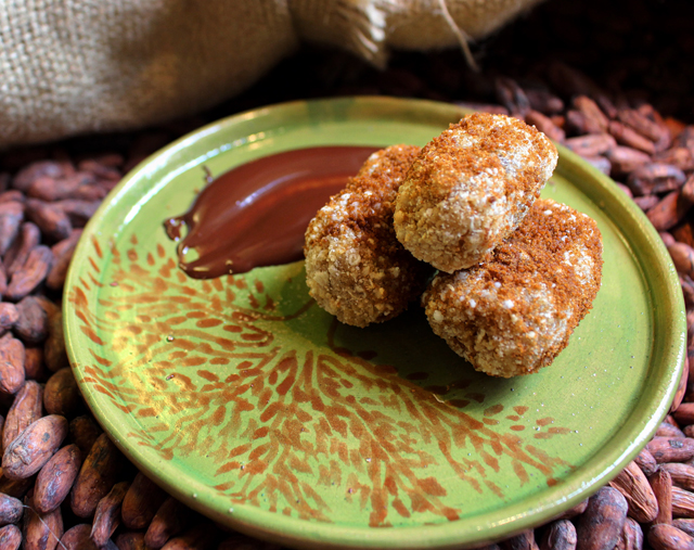 Bolinhos de estudante assados, polvilhados com chocolate e acompanhados por chocolate cremoso (R$ 10)