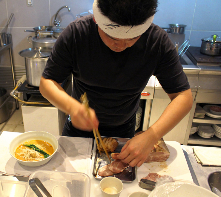 Luis em sua pequena cozinha aberta pro salão no 2nd Floor Noodle Bar