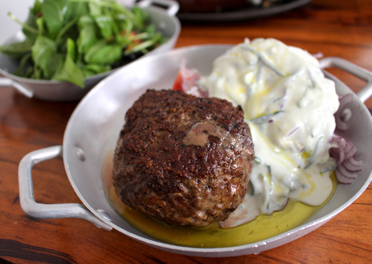 Bifteki: "burger" grego de carnes de porco e cordeiro com tzatziki e cebola roxa