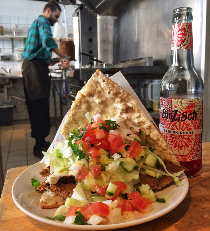 kebab vegetariano belamente condimentado e com textura semelhante a de carne. Acompanhando, suco orgânico 