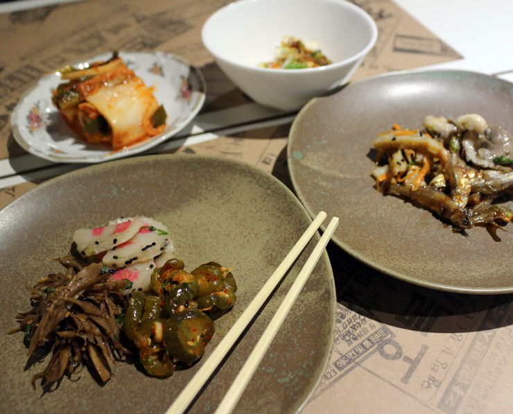 Ban Chan, seleção diária de acompanhamentos (R$ 16) que pode trazer manjubinha frita, tofu na chapa, crocante de massa de peixe, picles de bardana e, a estrela do local, o kimchi.