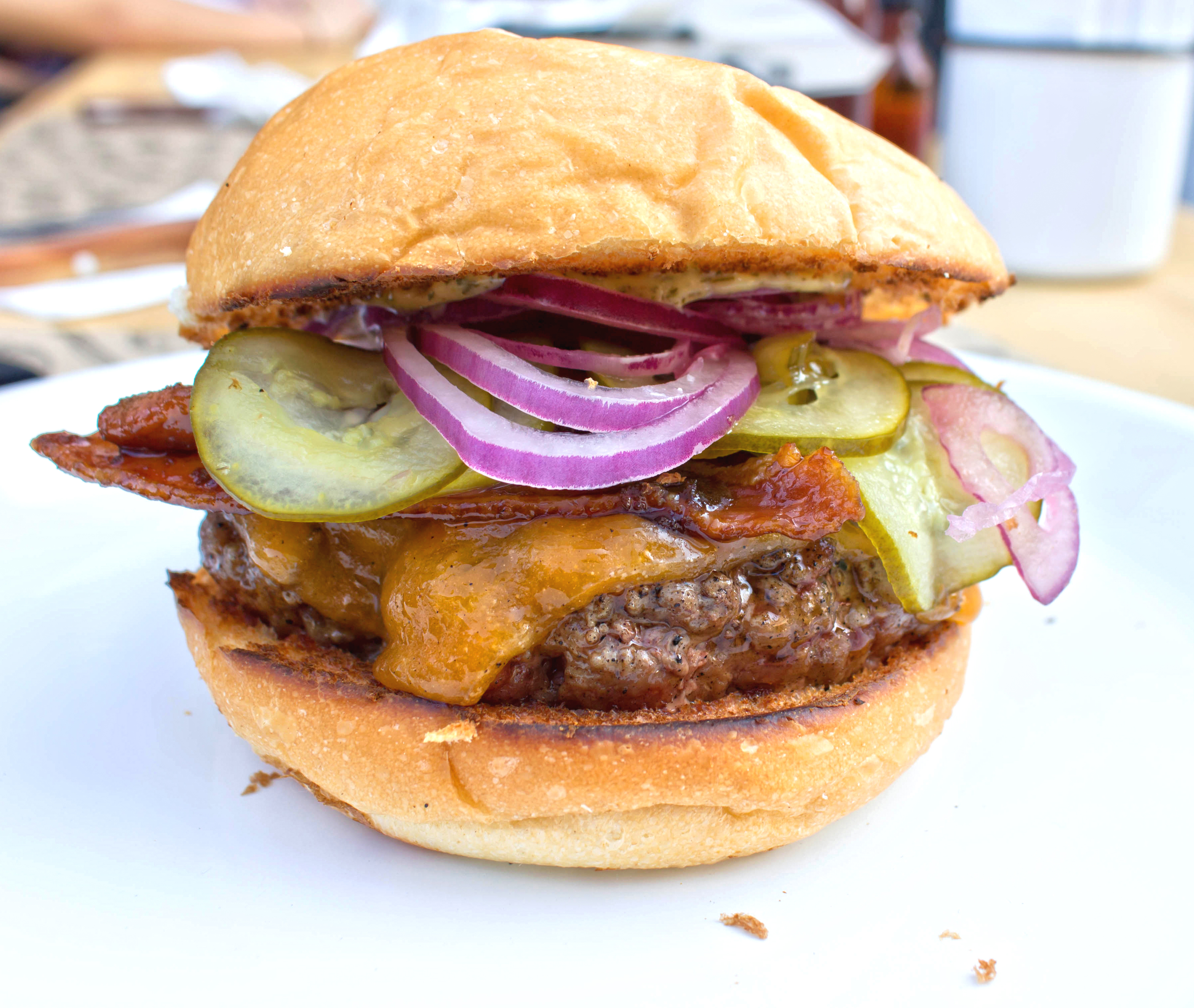 Hendrix: burger de blend bovino, cheddar, bacon caramelizado, picles de pepino, cebola roxa e maionese de endro