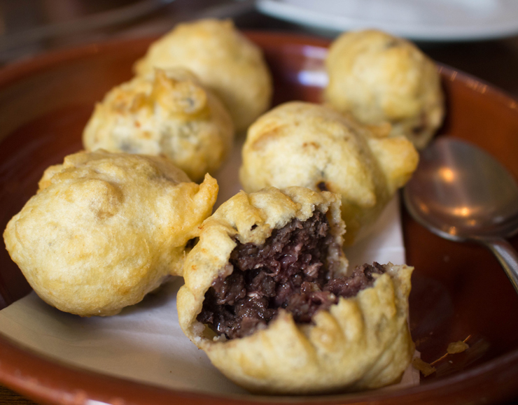 Buñuelos de morcilla (R$ 20), bolinhos de linguiça de carne suína, sangue de porco, cebola e especiarias, da Pirineus, empanados em massa lisa e crocante.